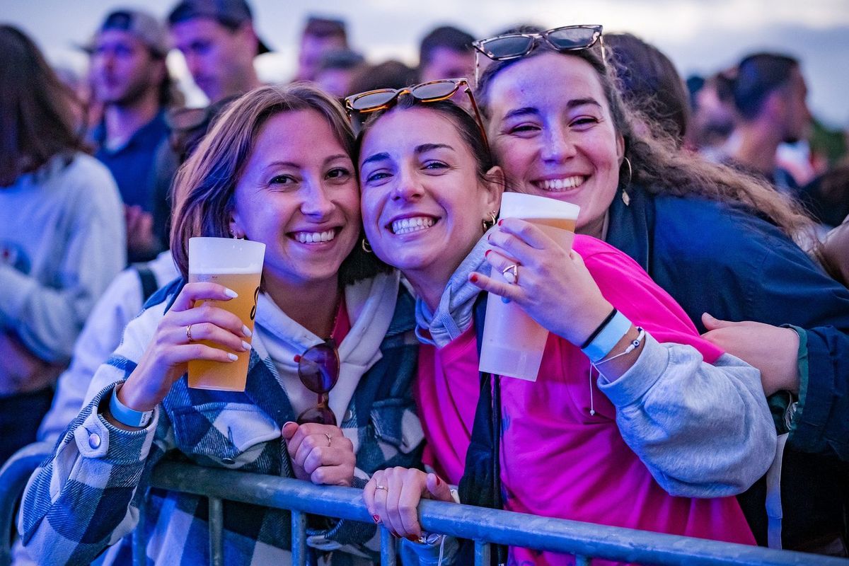 Trois amies souriantes avec des bières en soirée